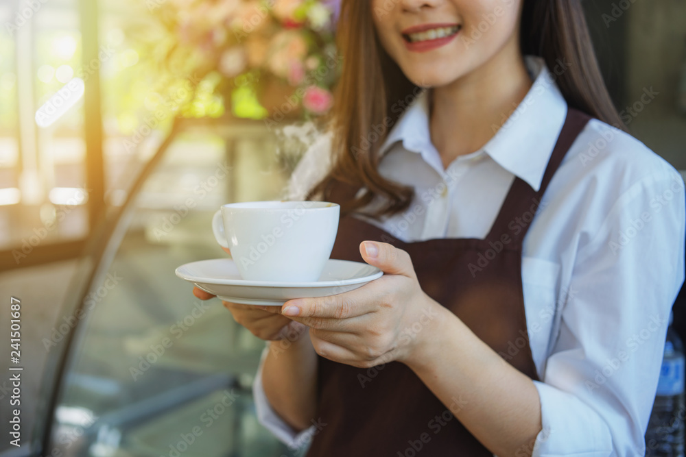 A young barista holding a coffee in the coffee shop A young barista holding a coffee in the coffee shop