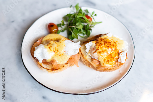 Eggs Benedict, English muffin topped with a poached egg, smoked salmon, and hollandaise sauce.