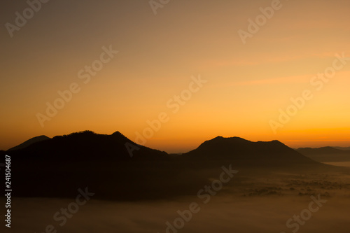 Beautiful sky sunrise. Mountain layer in morning sun ray and winter fog. © ptaa2010