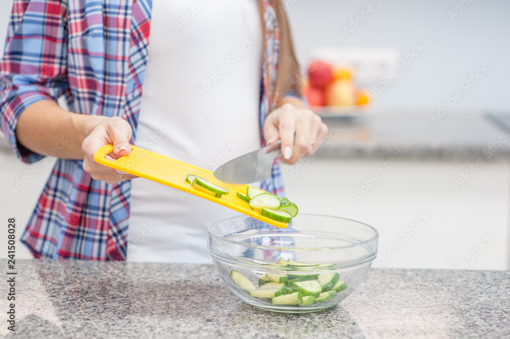 Close up pregnant woman at kitchen prepares a vegetable salad Close up pregnant woman at kitchen prepares a vegetable salad