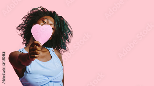 Young woman smiling and holding a pink heart , Be My Valentine photo