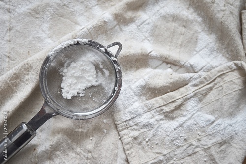 sieve and icing sugar on napkin