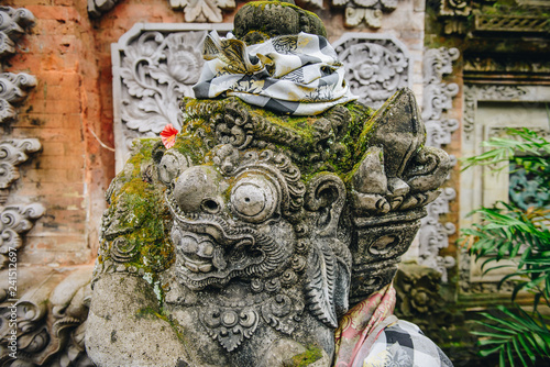 Traditional Balinese stone statue in front of Hindu temple in Ubud town of Bali, Indonesia. © boyloso
