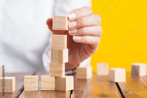 Woman hand arranging wooden cubes