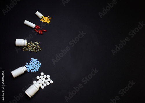 Different Medical pills, tablets and capsules on a black background