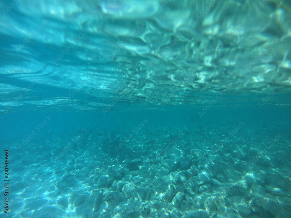 Underwater photo of mediterranean paradise island sandy beach with turquoise clear sea