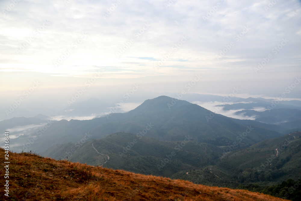 Distant hills and mountains above a sea of fog and mist, the mist in winter Landscape, view from top of mountain at Doi Phu Co, Mae Hong Sorn, Thailand 