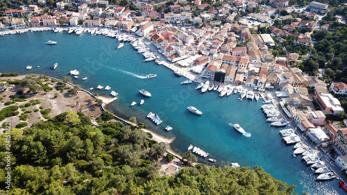 Aerial drone bird's eye view photo of iconic small safe port of Gaios with traditional Ionian architecture and sail boats docked, Paxos island, Ionian, Greece © aerial-drone