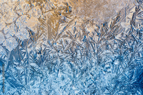 Blue beautiful winter frost patterns, abstract frost flowers texture on the road