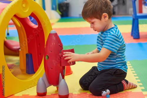 child of three years old is playing in the child's garden. boy smiling spends fun time in the children's room photo