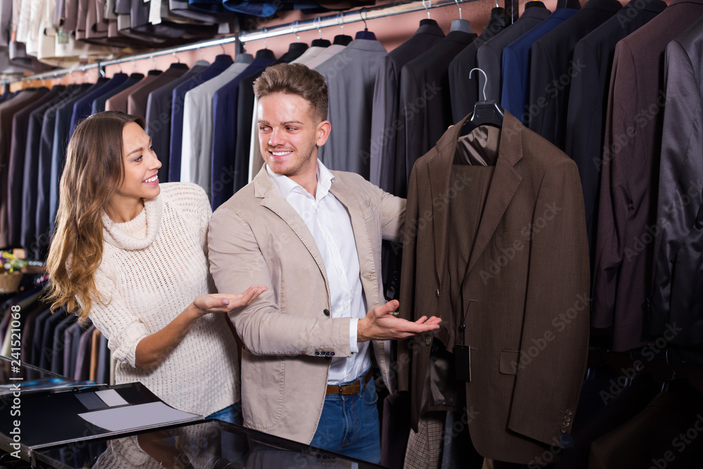 Fototapeta premium Laughing couple examining various suits
