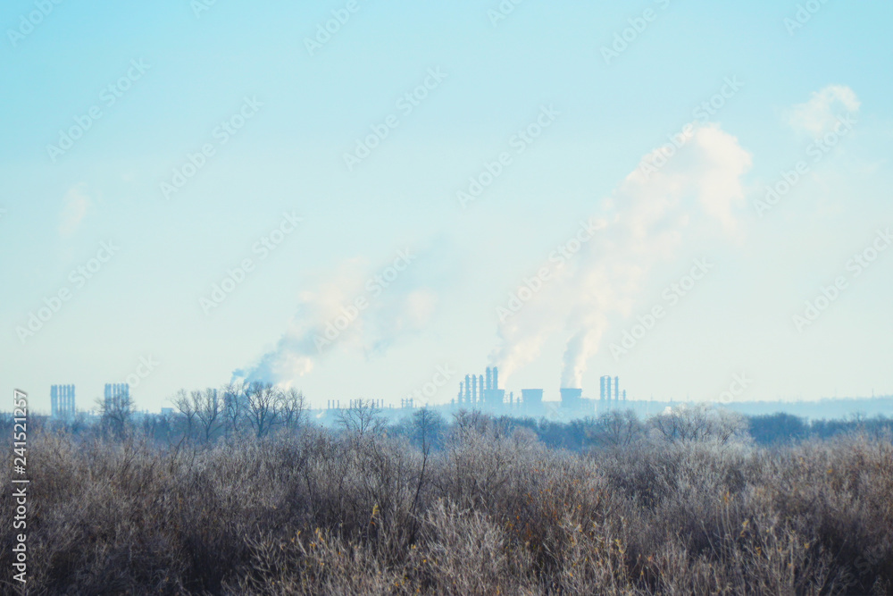 Modern landscape with factory pipes at distance from which smoke is polluting the air Modern landscape with factory pipes at distance from which smoke is polluting the air