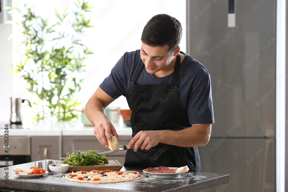 Young man preparing tasty pizza at table Young man preparing tasty pizza at table