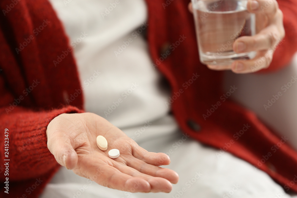 Obraz premium Elderly woman taking pills, closeup