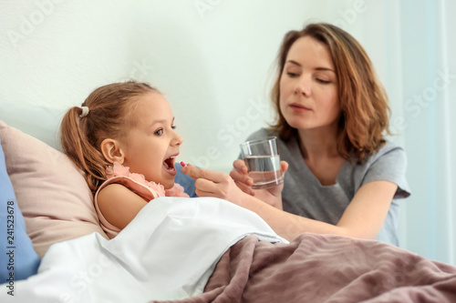 Young woman giving pill for...