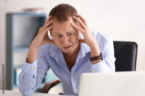 Man having panic attack at workplace in office