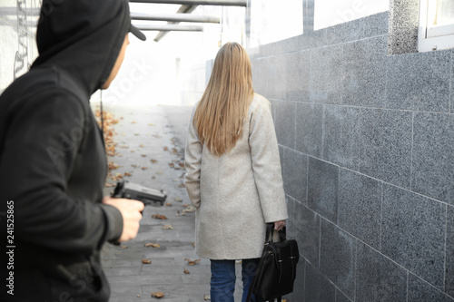 Εκτύπωση καμβά Male thief with gun is going to steal from woman outdoors