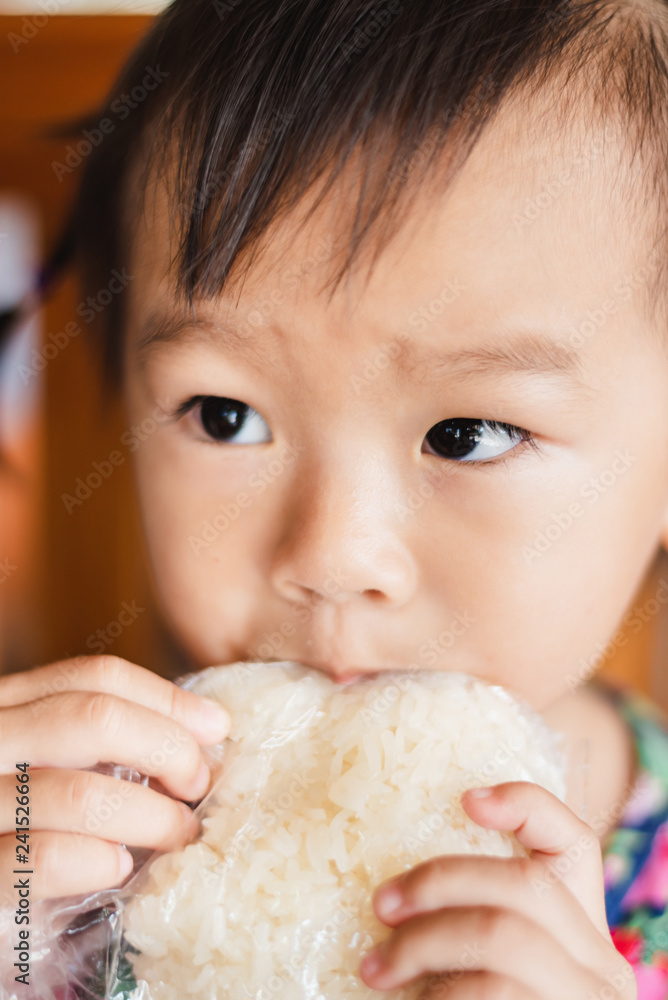 child little girl eating sticky rice in plastic bag child little girl eating sticky rice in plastic bag
