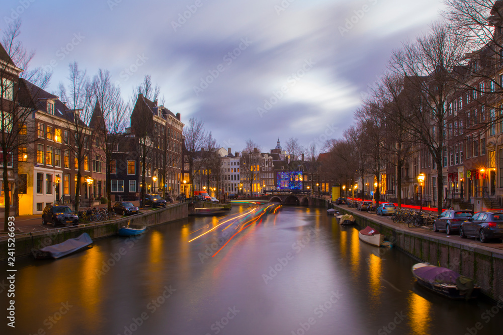 View on romantic canal Keizergracht  in Amsterdam at night with city light and reflection on water