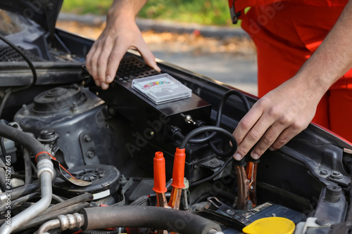 Male mechanic charging a car battery © Pixel-Shot