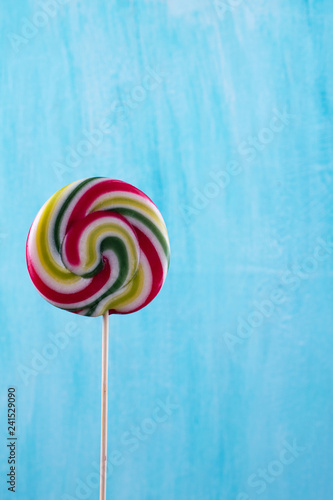 Colorful striped lollipop minimal concept on turquoise copy space background