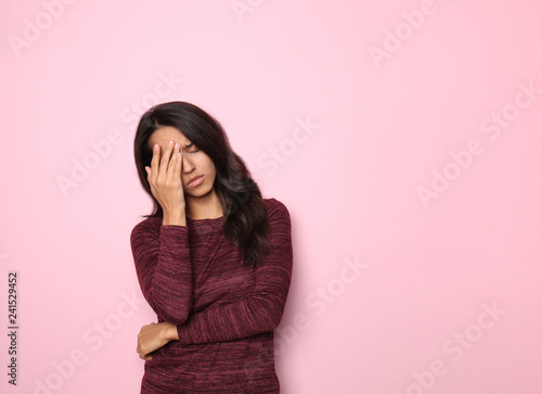 Stressed young woman on color background photo