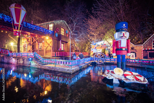 Fototapeta Naklejka Na Ścianę i Meble -  Night view of the greek Christmas market “Oneiroupoli” with lights, figurines around the river in Drama, Greece