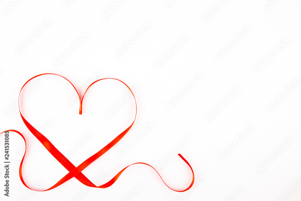 Isolated silk red ribbon laid in heart shape on bright white background. Festive decoration. Mother's, Women's, Wedding, Happy st Valentines Day concept, 14th February. Top view, flat lay, close up. Isolated silk red ribbon laid in heart shape on bright white background. Festive decoration. Mother's, Women's, Wedding, Happy st Valentines Day concept, 14th February. Top view, flat lay, close up.