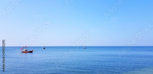 Fishing boat floating on the sea with clear blue sky and copy space - Beauty of Landscape, Ocean and Fishery concept 
