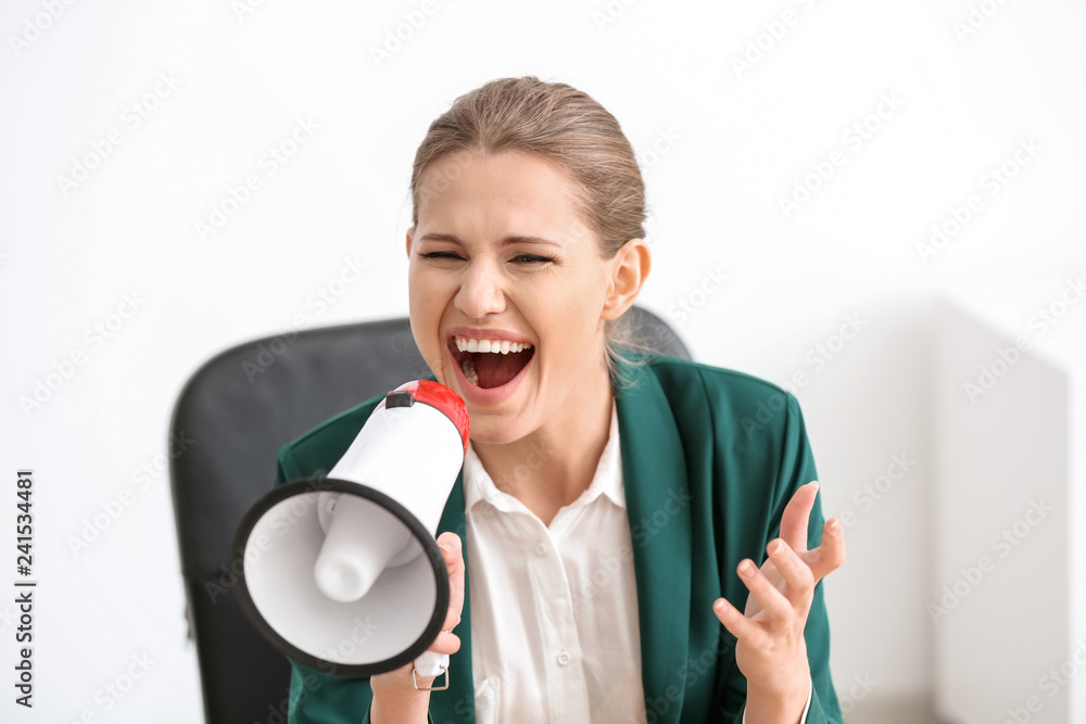 Young businesswoman using megaphone in office Young businesswoman using megaphone in office