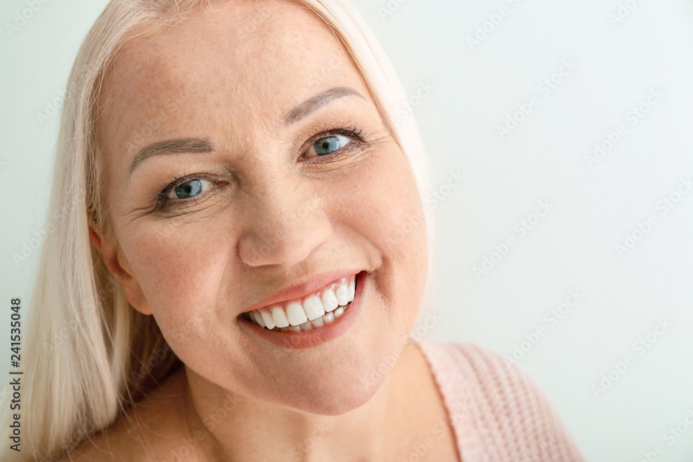 Portrait of beautiful mature woman on light background Portrait of beautiful mature woman on light background