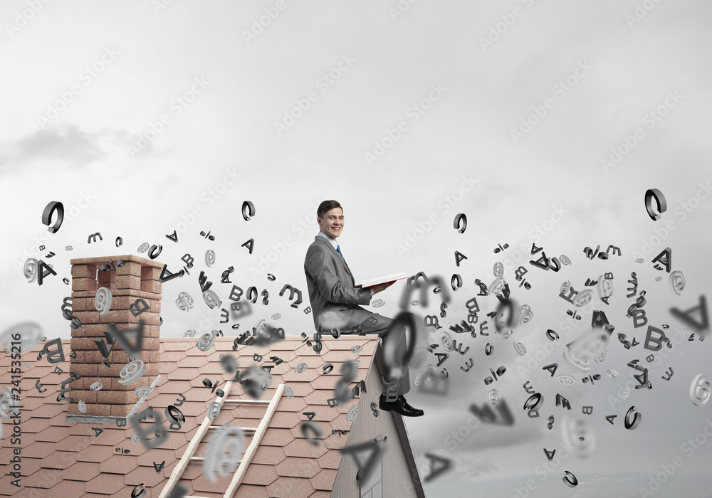 Man on brick roof reading book and symbols flying around Man on brick roof reading book and symbols flying around