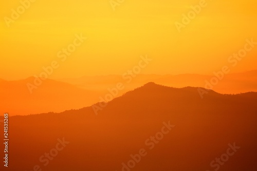 Beautiful orange sunlight or sunrise in morning with silhouette of big mountain for background at Doi Chiang Dao, Doi Luang Chiang Dao, Chiangmai, Thailand-Landmark for travel and Beauty of Nature 