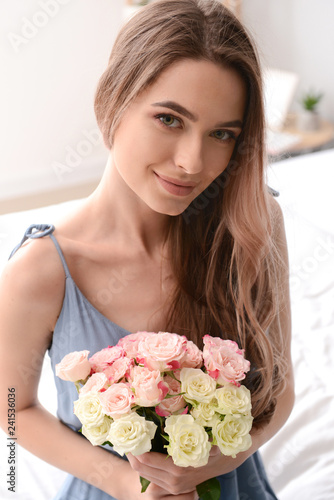 Portrait of beautiful young woman with bouquet of flowers