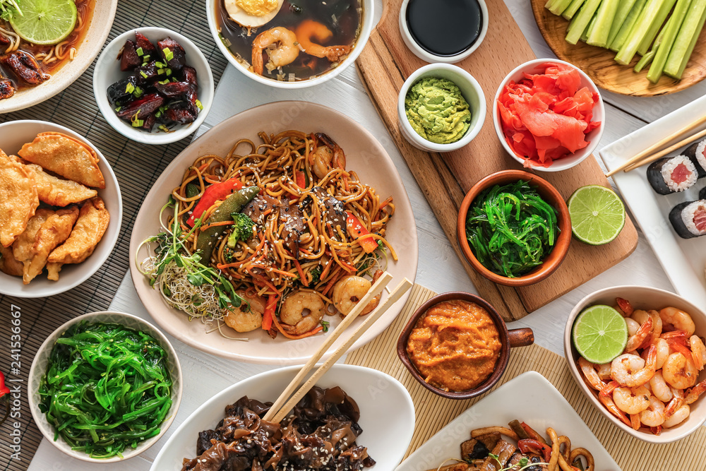 Assortment of Chinese food on white table Assortment of Chinese food on white table