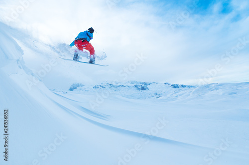 Snowboarder jumping from the rock