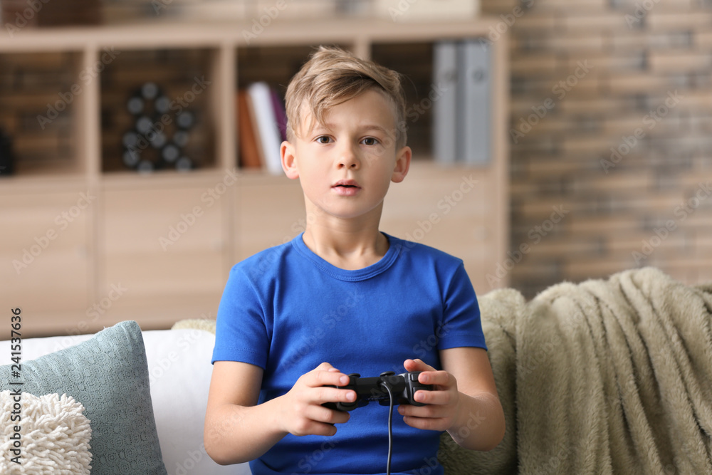 Cute boy playing video game at home Cute boy playing video game at home