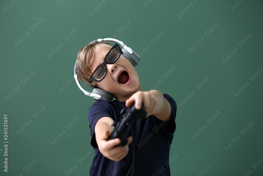 Emotional boy playing video game on color background Emotional boy playing video game on color background