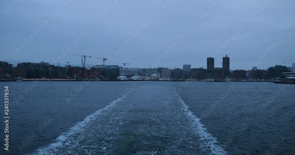 Boat captured from the stern from the city with the streams of water that the ship leaves behind. Captured in Oslo, Norway. Boat captured from the stern from the city with the streams of water that the ship leaves behind. Captured in Oslo, Norway.
