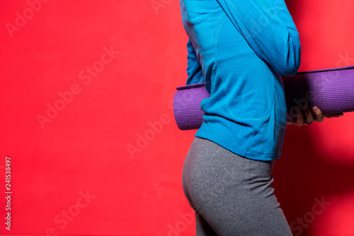 Sporty yoga girl with yoga mat isolated over bright background © Leart