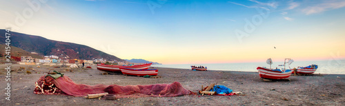 Fishing nets and boats on the beach with Oued Laou in the background, a small fishing village in the province of Chauen, in the Tangier-Tetouan region, Morocco © juanorihuela