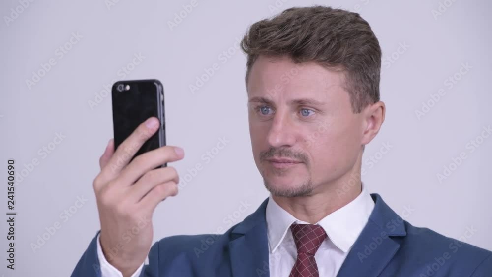 Face of happy bearded businessman smiling while using phone Face of happy bearded businessman smiling while using phone