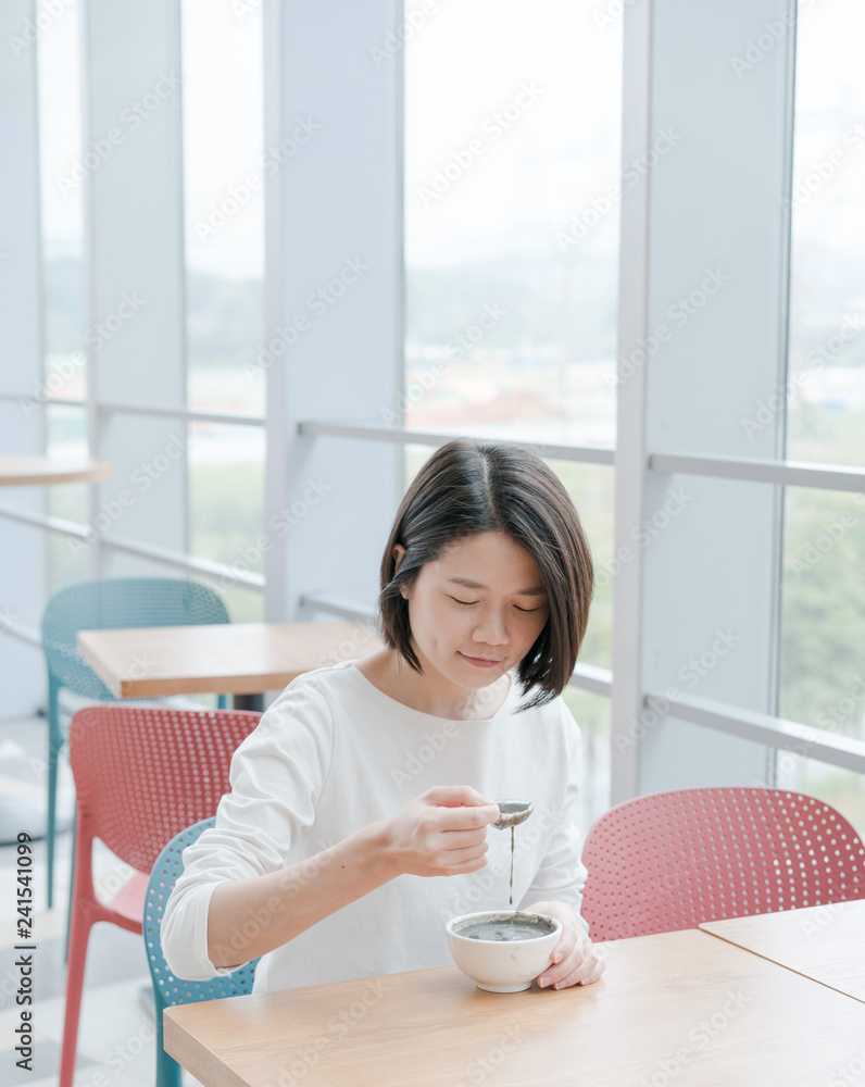 Asian female eat black sesame paste