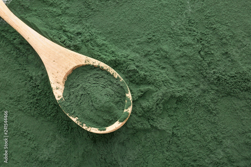 Wooden spoon on spirulina powder