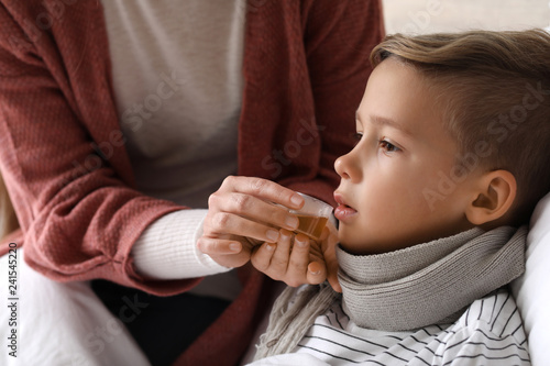 Mother giving medicine to h...