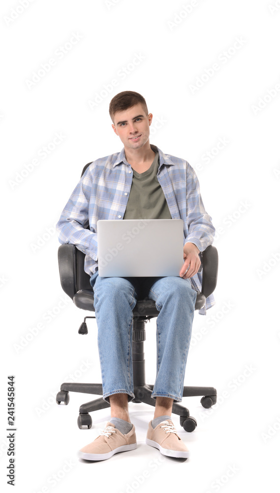 Young man with laptop sitting in armchair on white background