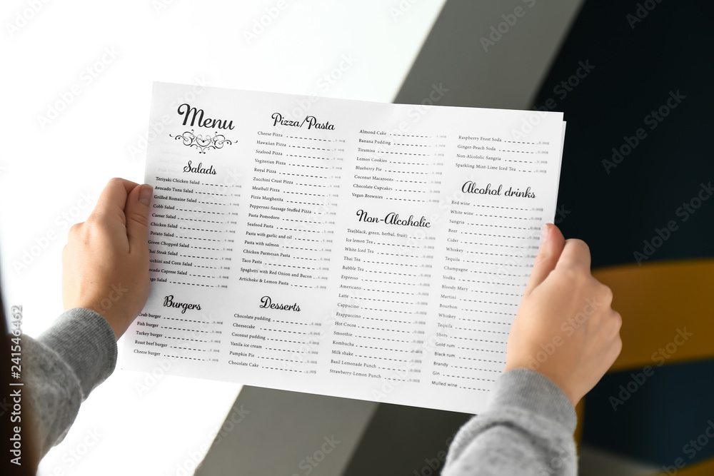 Obraz premium Woman reading menu in cafe