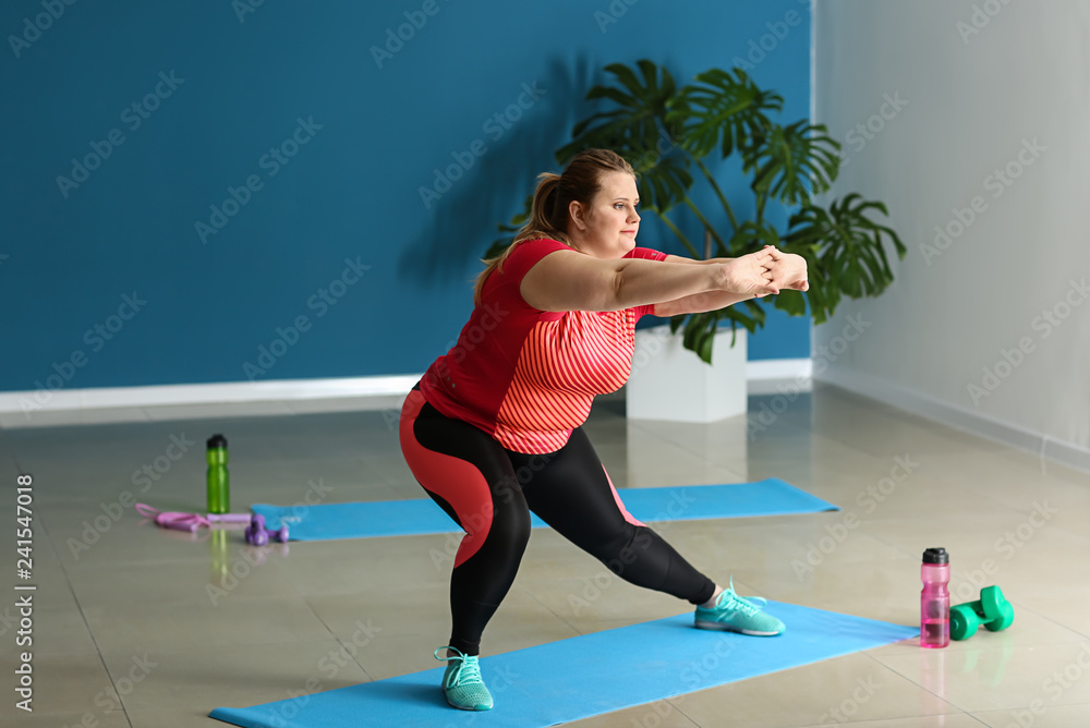 Beautiful plus size girl training in gym. Concept of body positivity