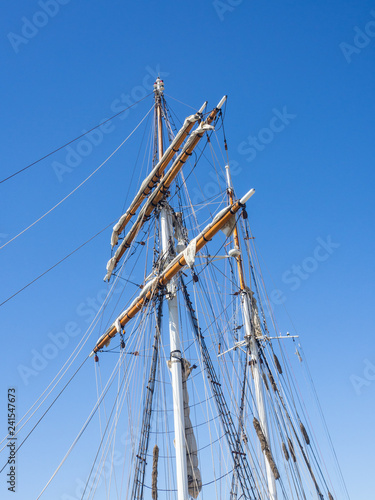 Wooden sailing ship pole isolated on blue sky background.