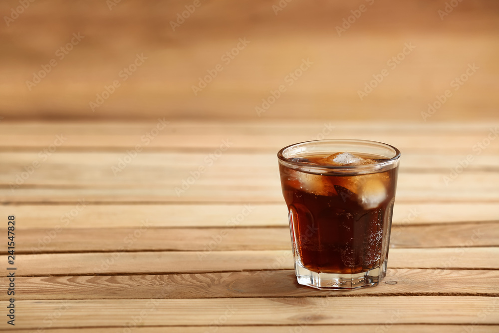 Glass of soda with ice on wooden table Glass of soda with ice on wooden table